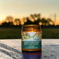 Northbound candle in amber glass jar, cedar and fir needle scent, hand poured in Medicine Hat, Alberta